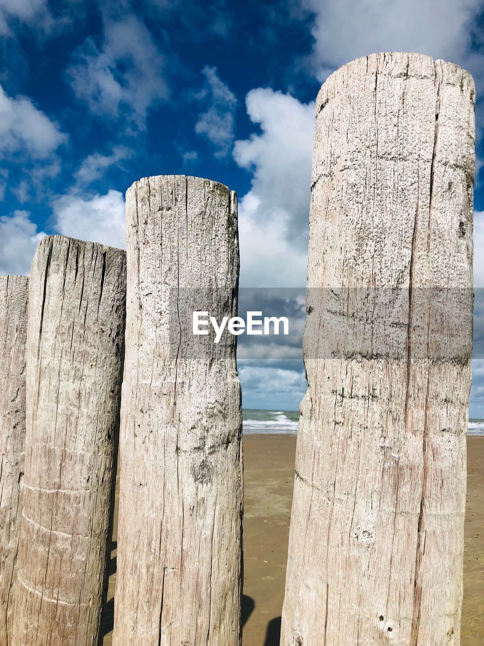 LOW ANGLE VIEW OF WOODEN POST AND FENCE AGAINST SKY