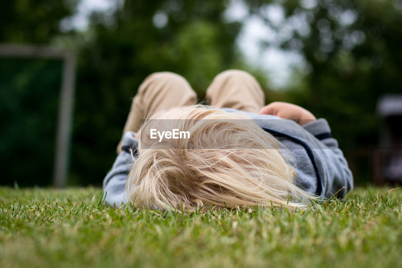 Baby boy lying on grassy field