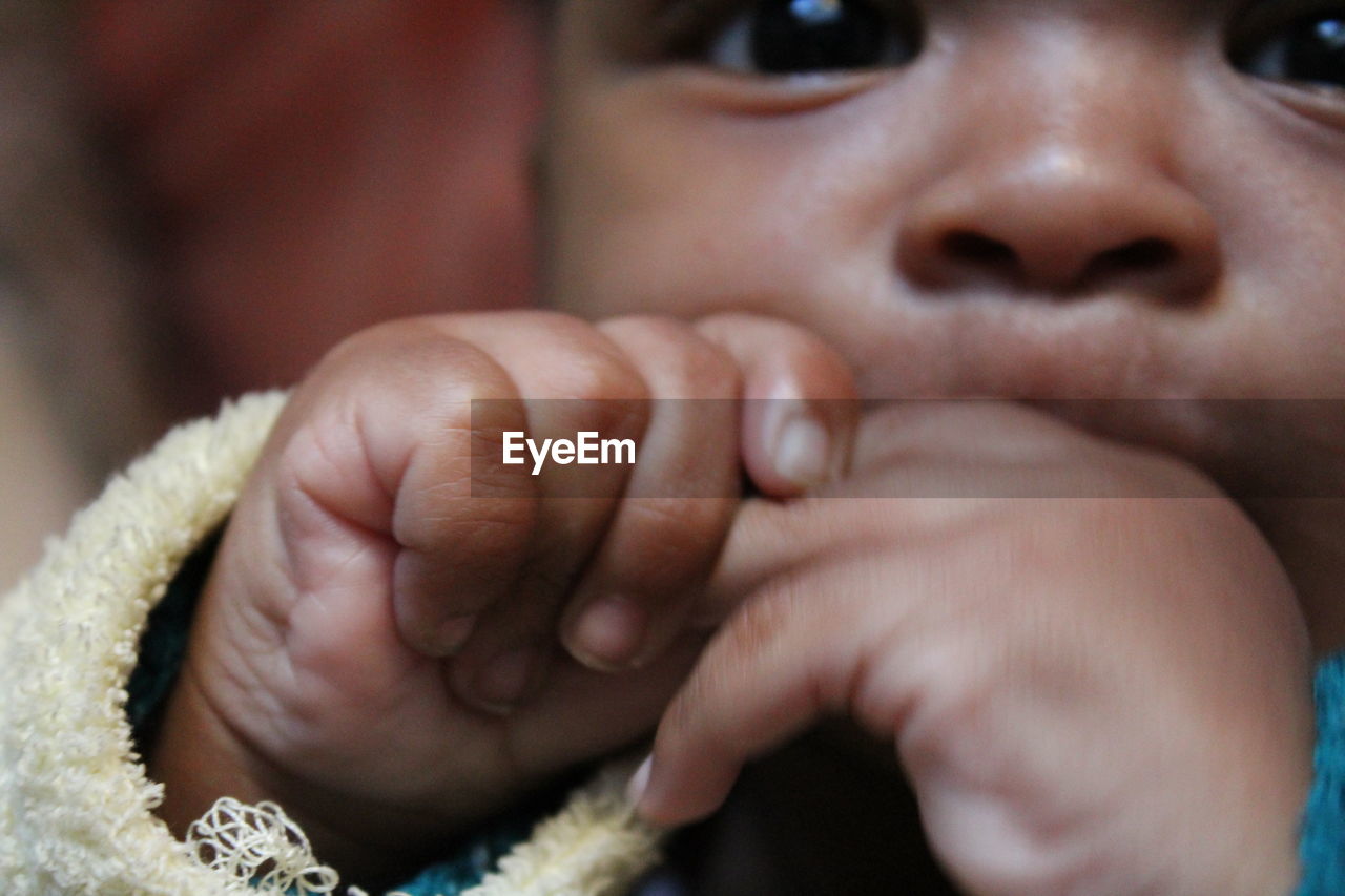 Close-up of baby boy with finger in mouth