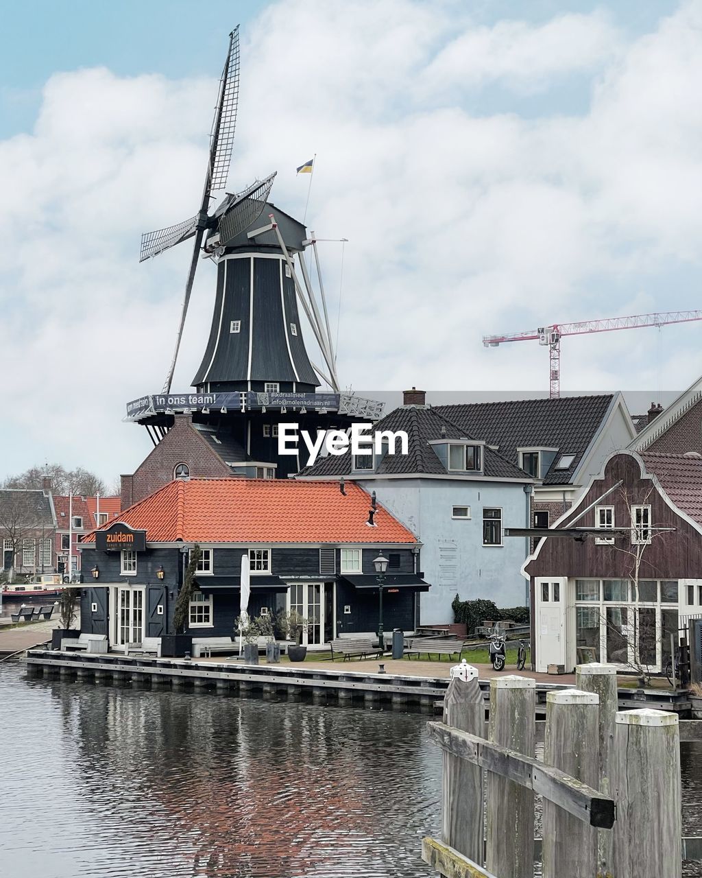 architecture, water, built structure, building exterior, sky, cloud, waterway, nature, building, windmill, harbor, environment, renewable energy, nautical vessel, no people, wind power, mill, environmental conservation, day, transportation, alternative energy, wind turbine, turbine, house, vehicle, canal, outdoors, town, power generation, city, the past, history, sea, pier, travel destinations, waterfront, travel, industry