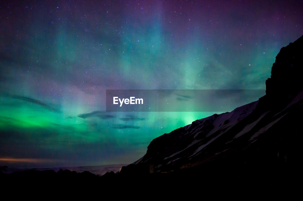 Scenic view of mountain against aurora borealis