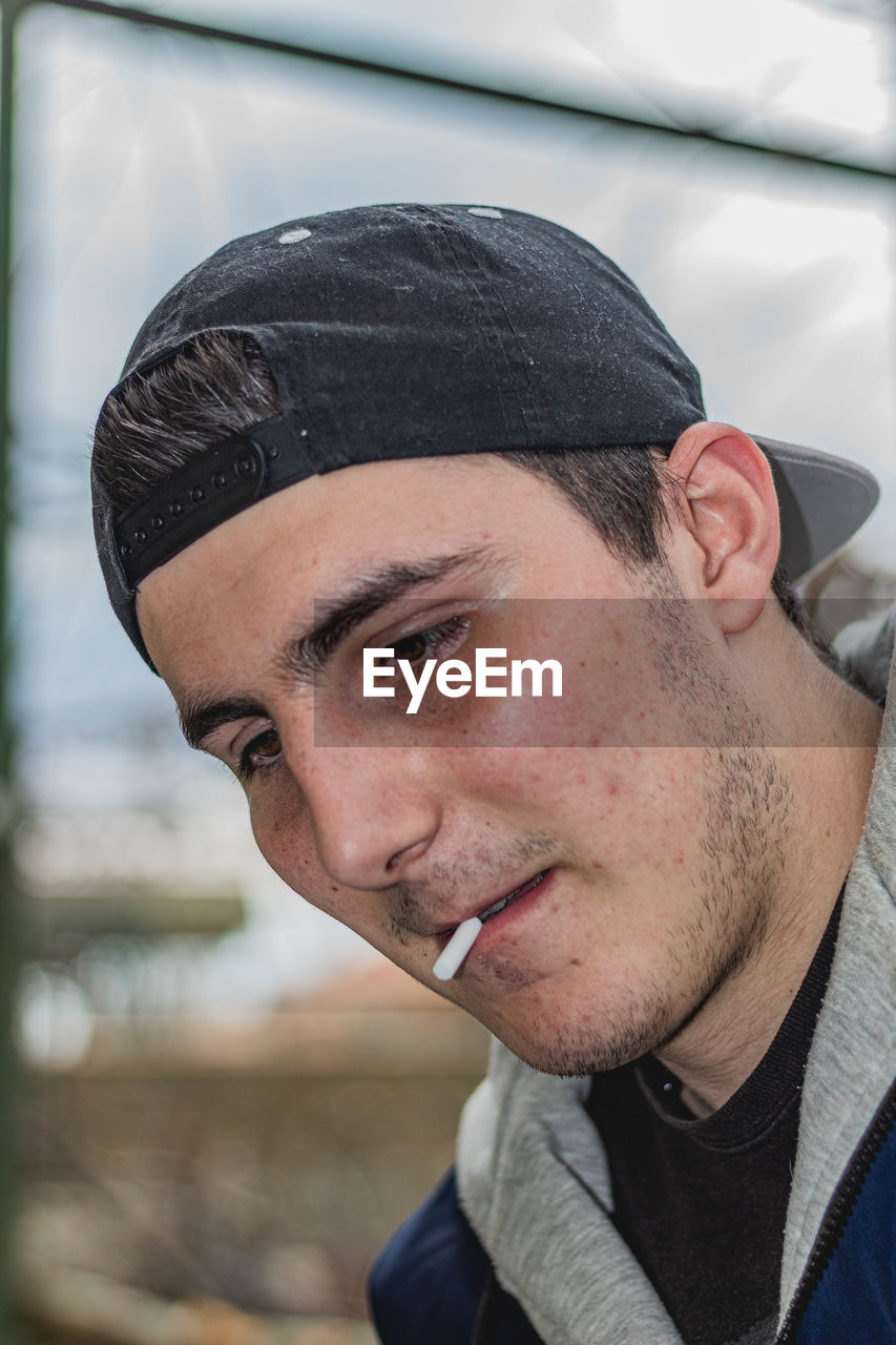 CLOSE-UP PORTRAIT OF YOUNG MAN WEARING EYEGLASSES