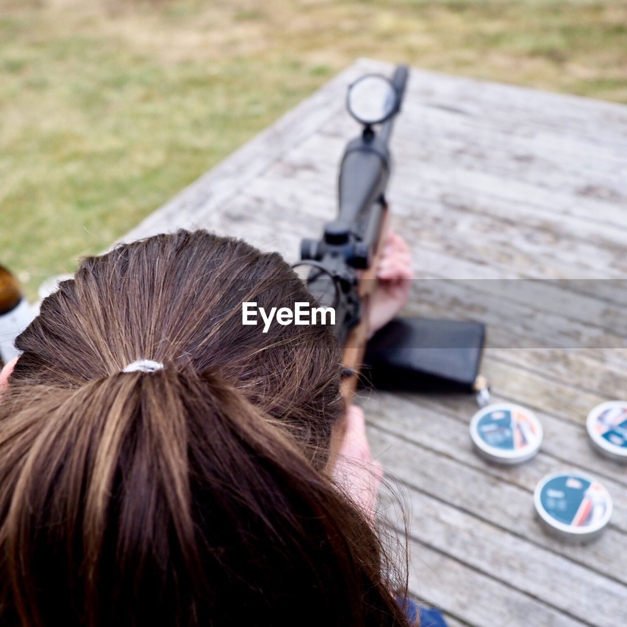 Rear view of woman holding rifle 