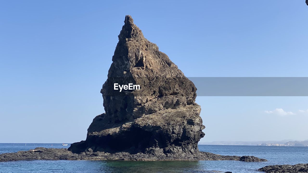 water, sea, sky, rock, land, beauty in nature, nature, scenics - nature, ocean, beach, coast, rock formation, tranquility, blue, shore, cliff, tranquil scene, clear sky, body of water, no people, terrain, day, islet, bay, travel destinations, outdoors, stack rock, horizon over water, non-urban scene, idyllic, tower, horizon, sunny, coastline, formation, travel, sunlight, landscape