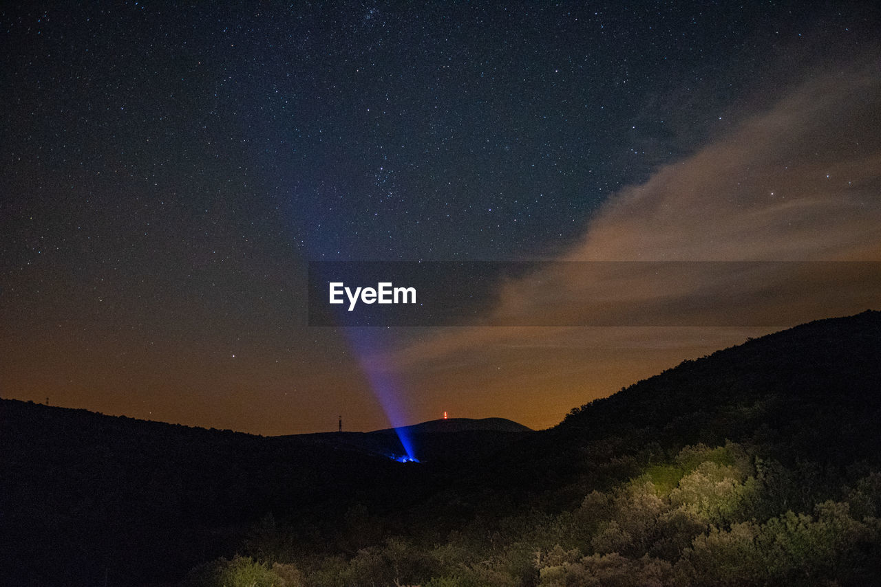 Scenic view of silhouette mountain against sky at night