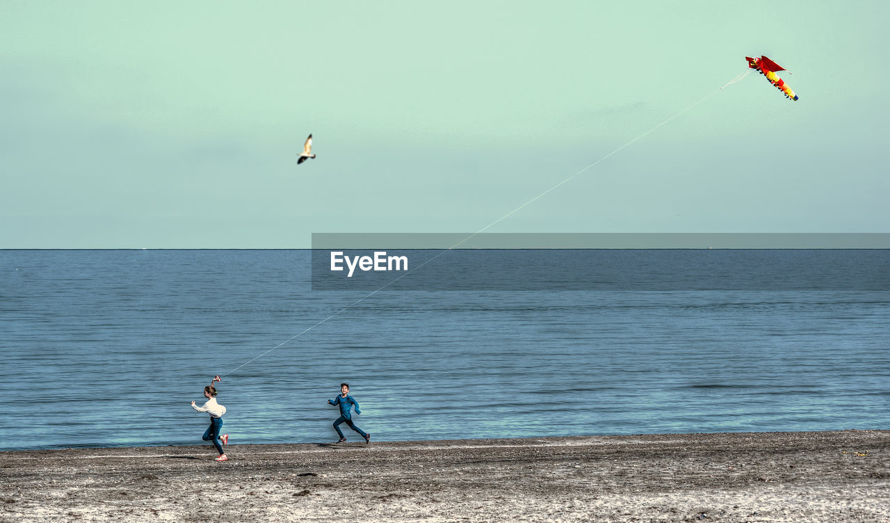 PEOPLE AT SEA AGAINST SKY