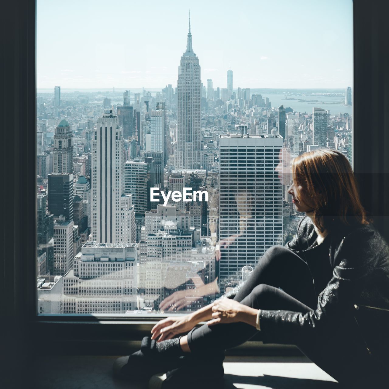 WOMAN LOOKING AT CITY BUILDINGS AGAINST SKY