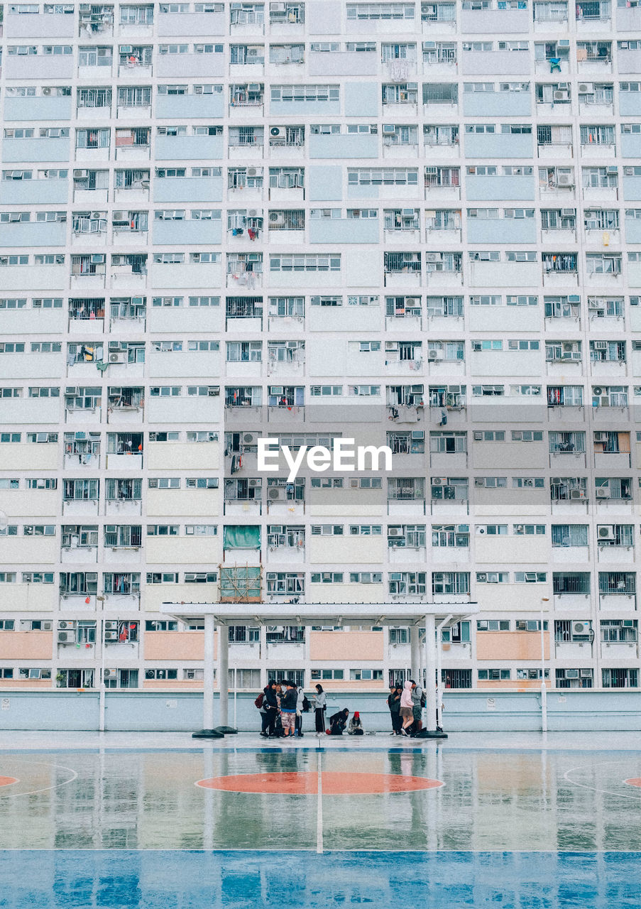 People at basketball court against residential building