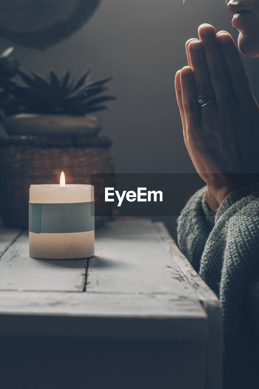 midsection of woman holding illuminated candles