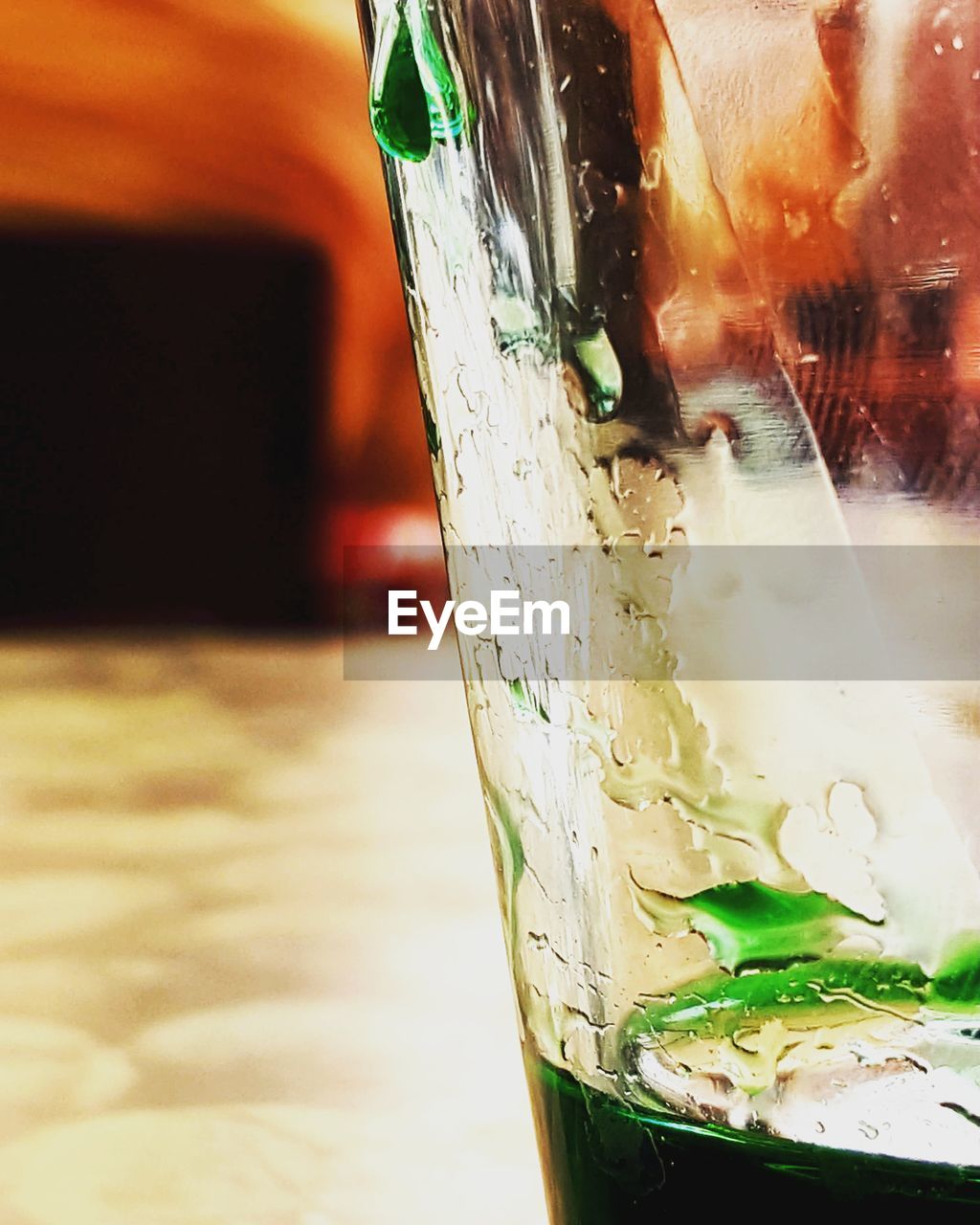 CLOSE-UP OF DRINK ON GLASS TABLE