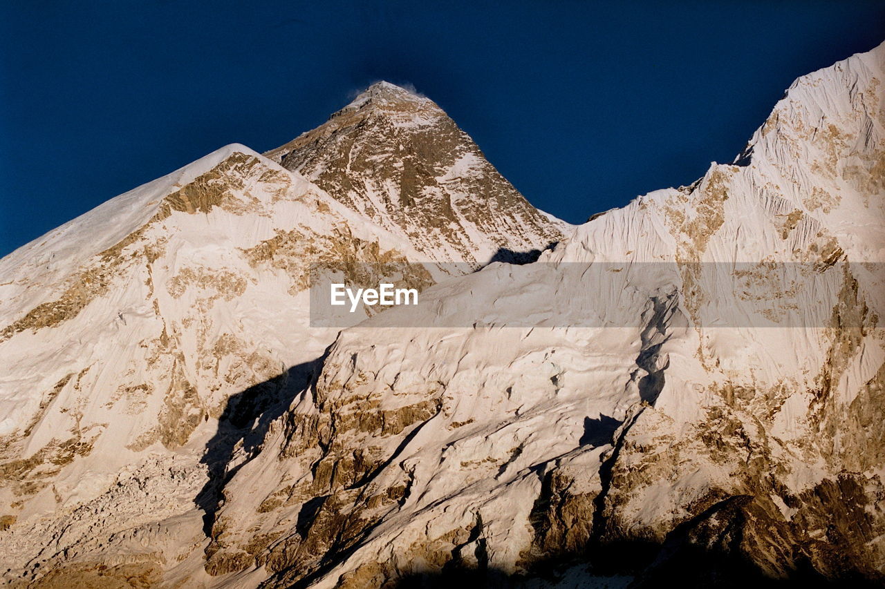 LOW ANGLE VIEW OF SNOWCAPPED MOUNTAINS AGAINST SKY