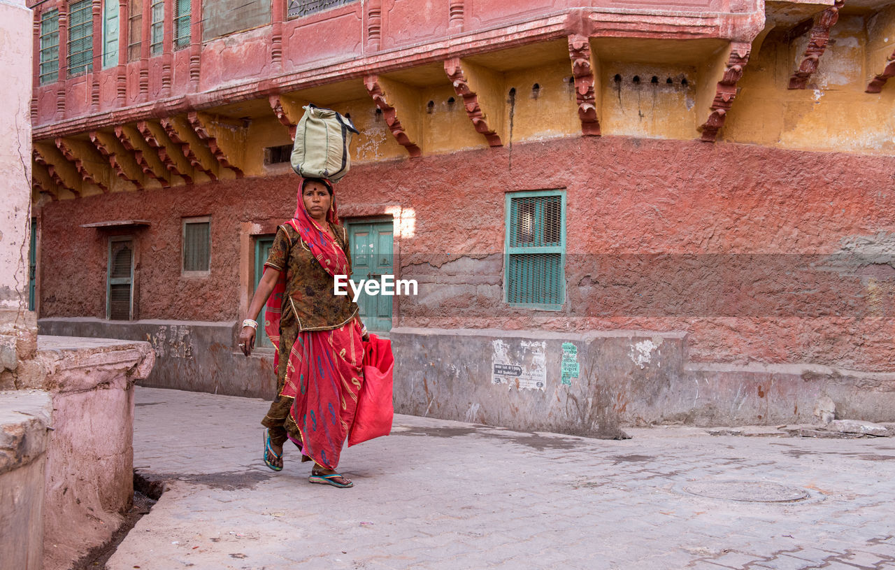 FULL LENGTH REAR VIEW OF WOMAN WALKING IN BUILDING