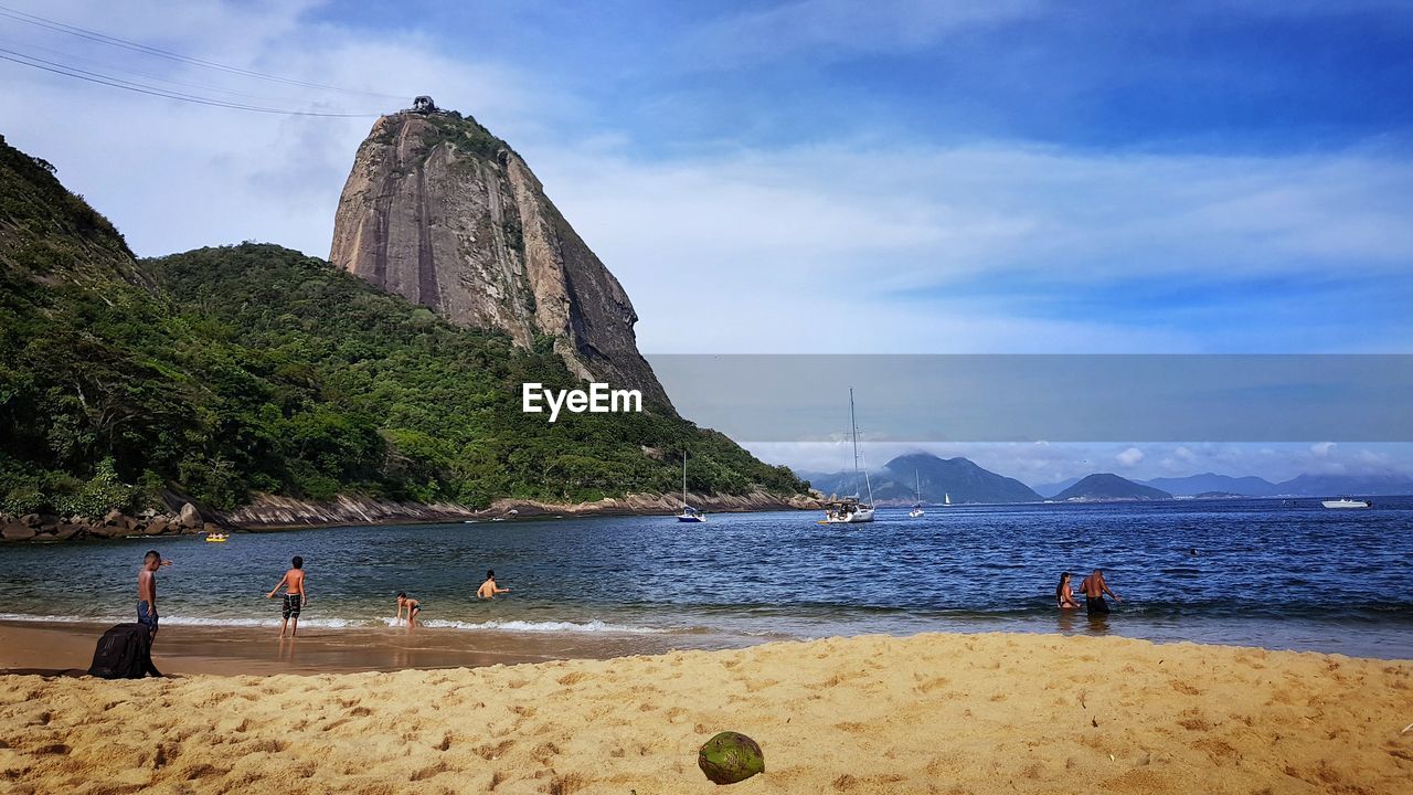 PEOPLE ON BEACH AGAINST SKY