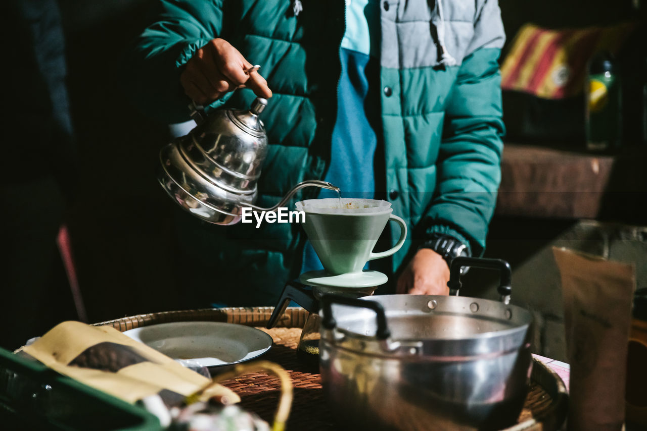 Midsection of man preparing coffee in kitchen