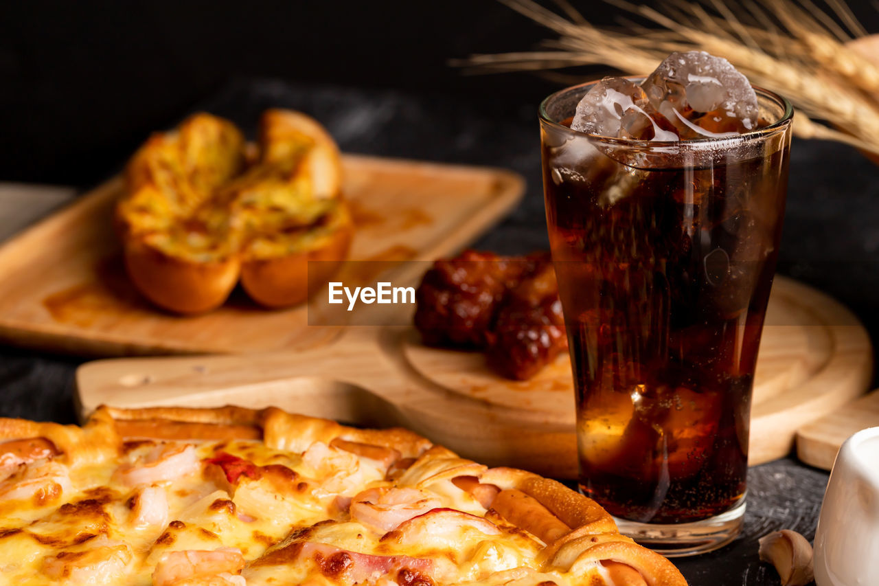 Pizza with cold drink on the black table