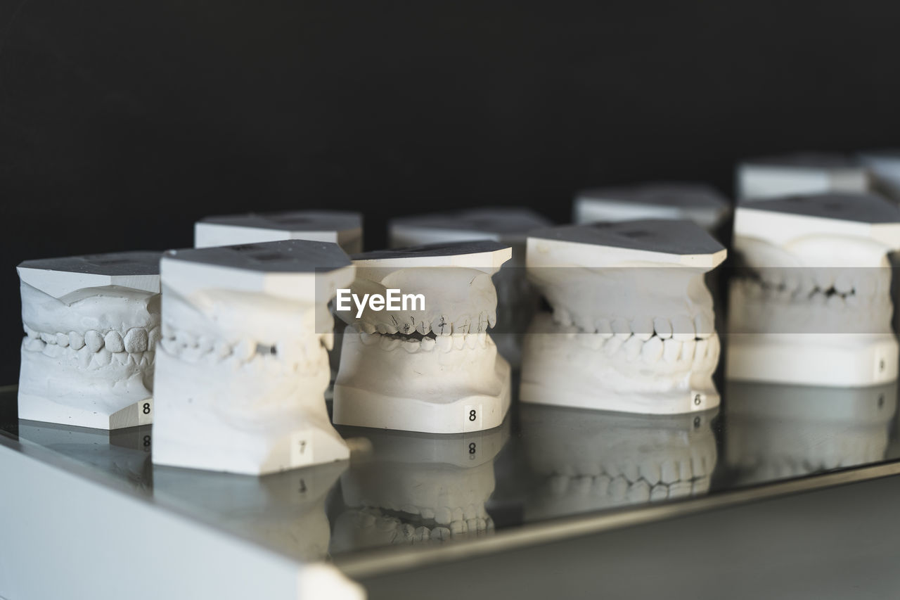 Close-up of dentures of table against black background