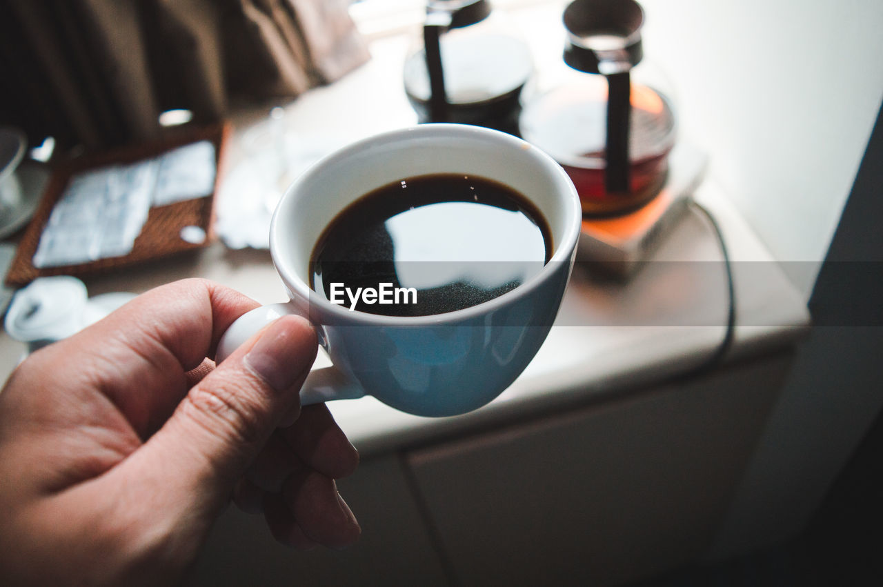 Cropped hand of person holding coffee cup