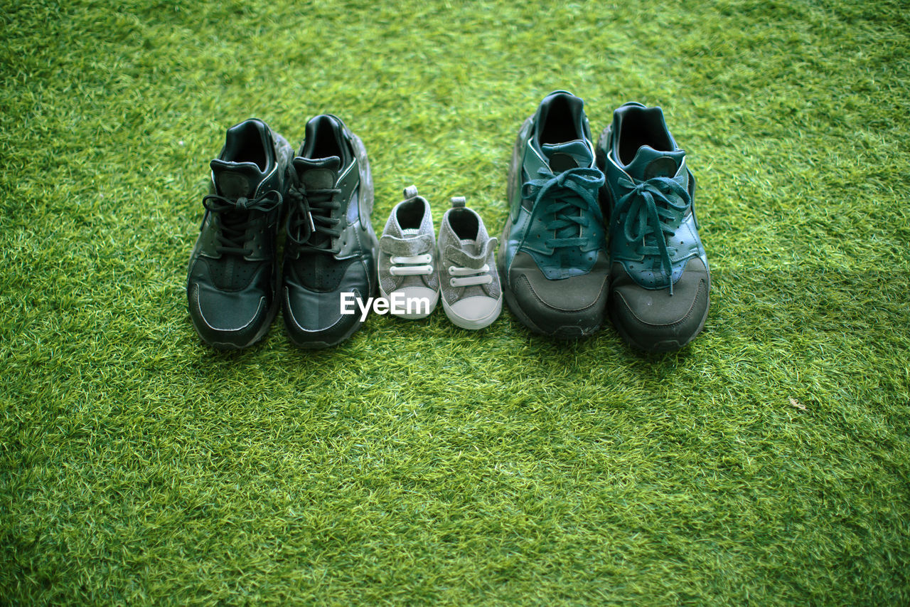 HIGH ANGLE VIEW OF SHOES ON GRASS