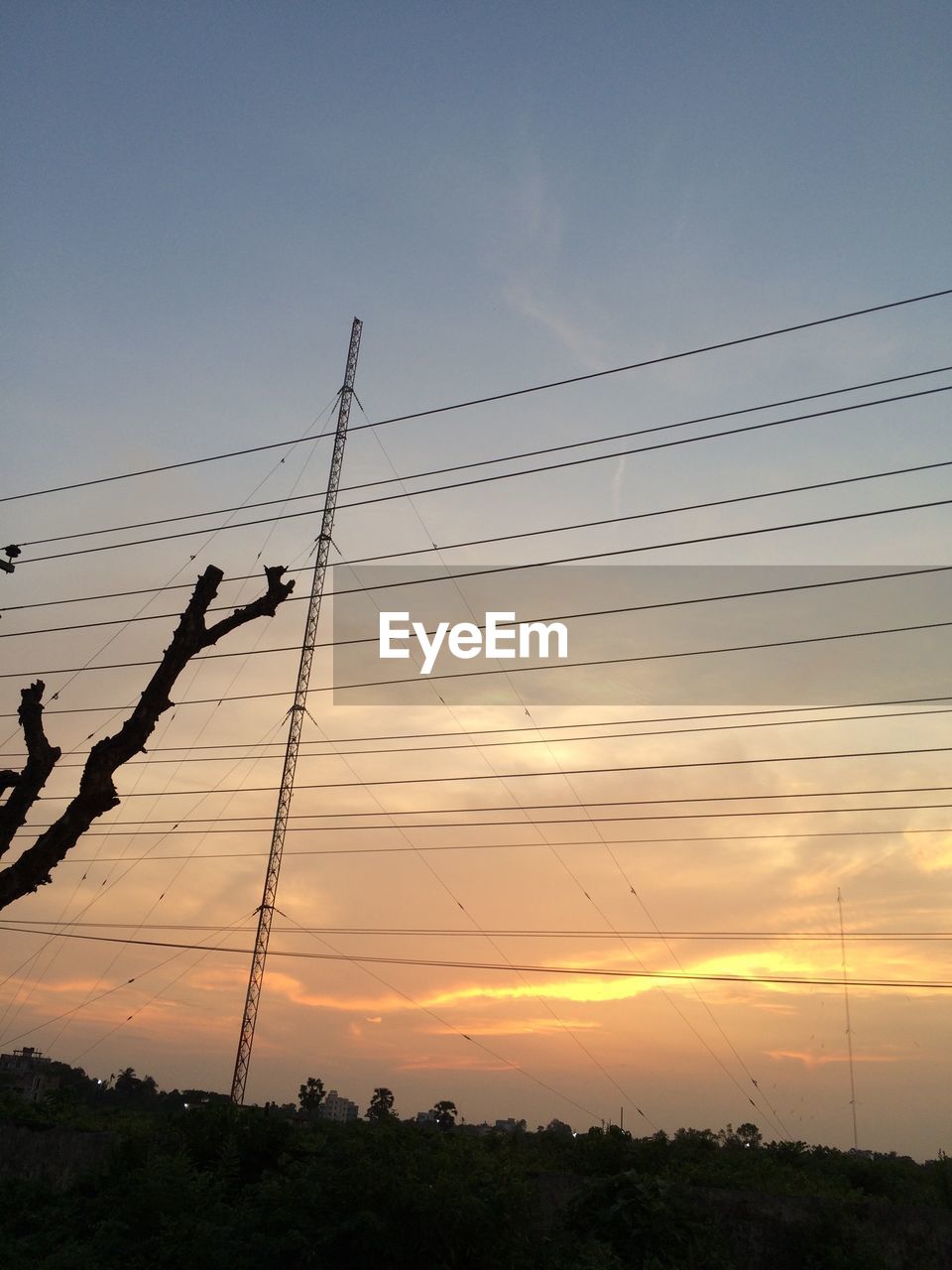 LOW ANGLE VIEW OF ELECTRICITY PYLON AT SUNSET