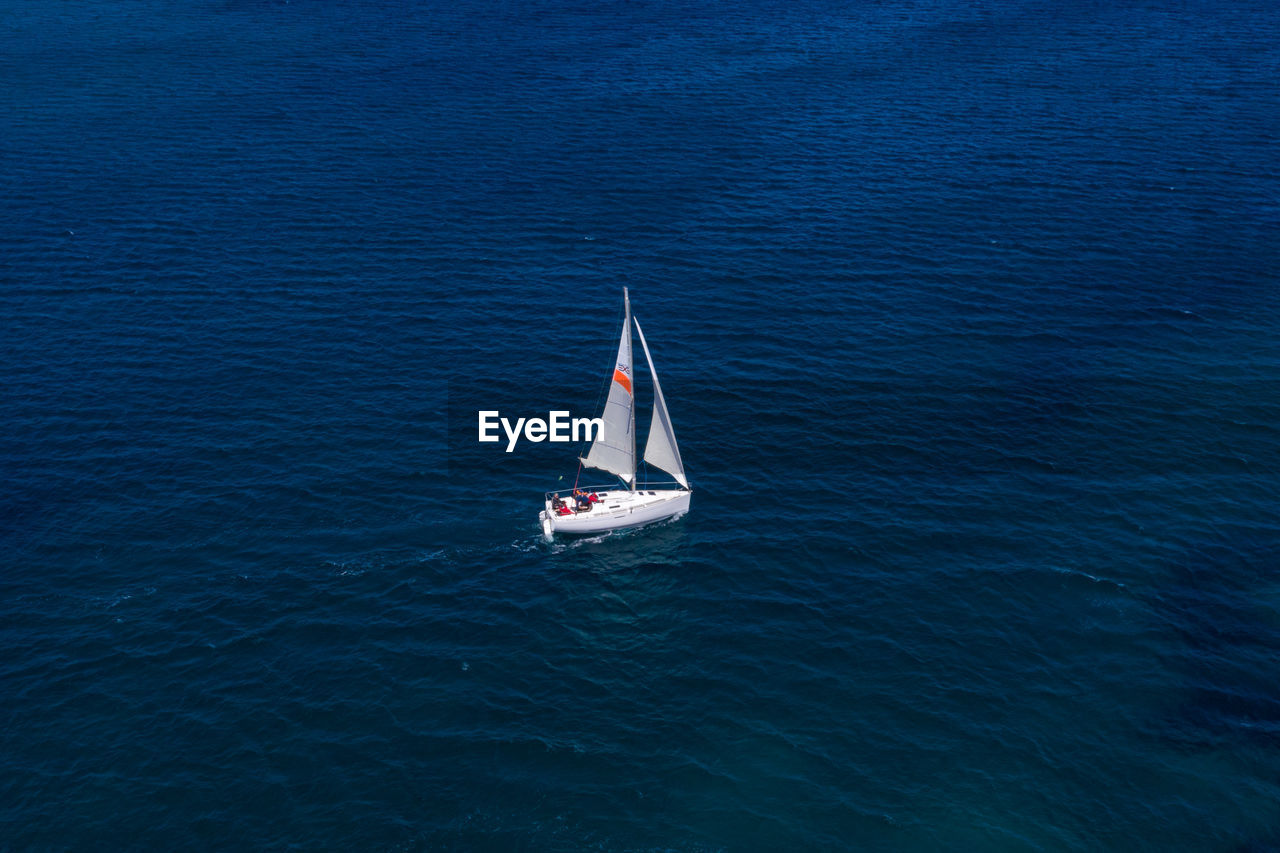 HIGH ANGLE VIEW OF SAILBOAT ON SEA