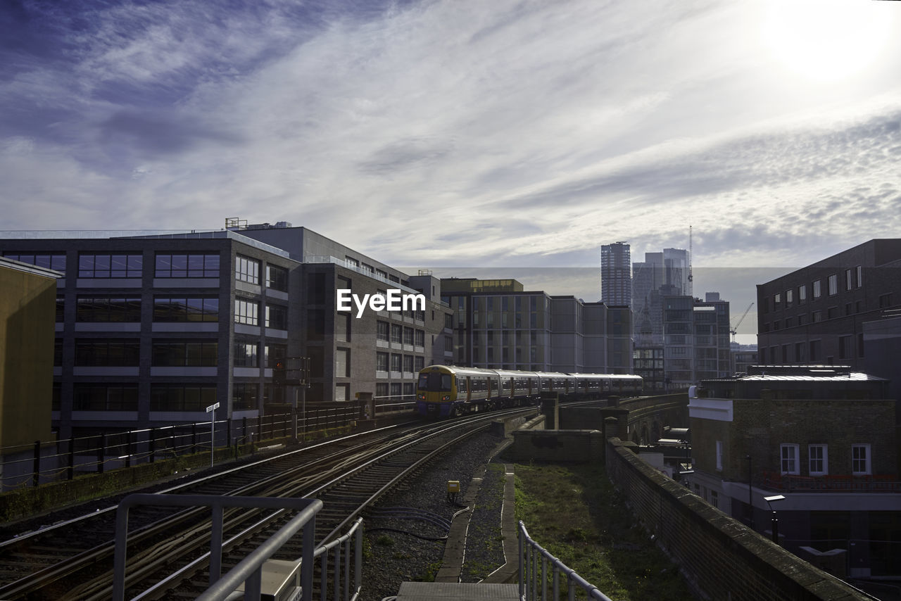 High angle view of railroad tracks amidst buildings against sky