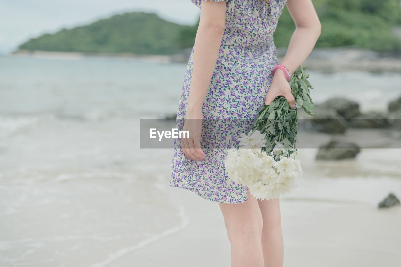 Rear view of woman standing on beach