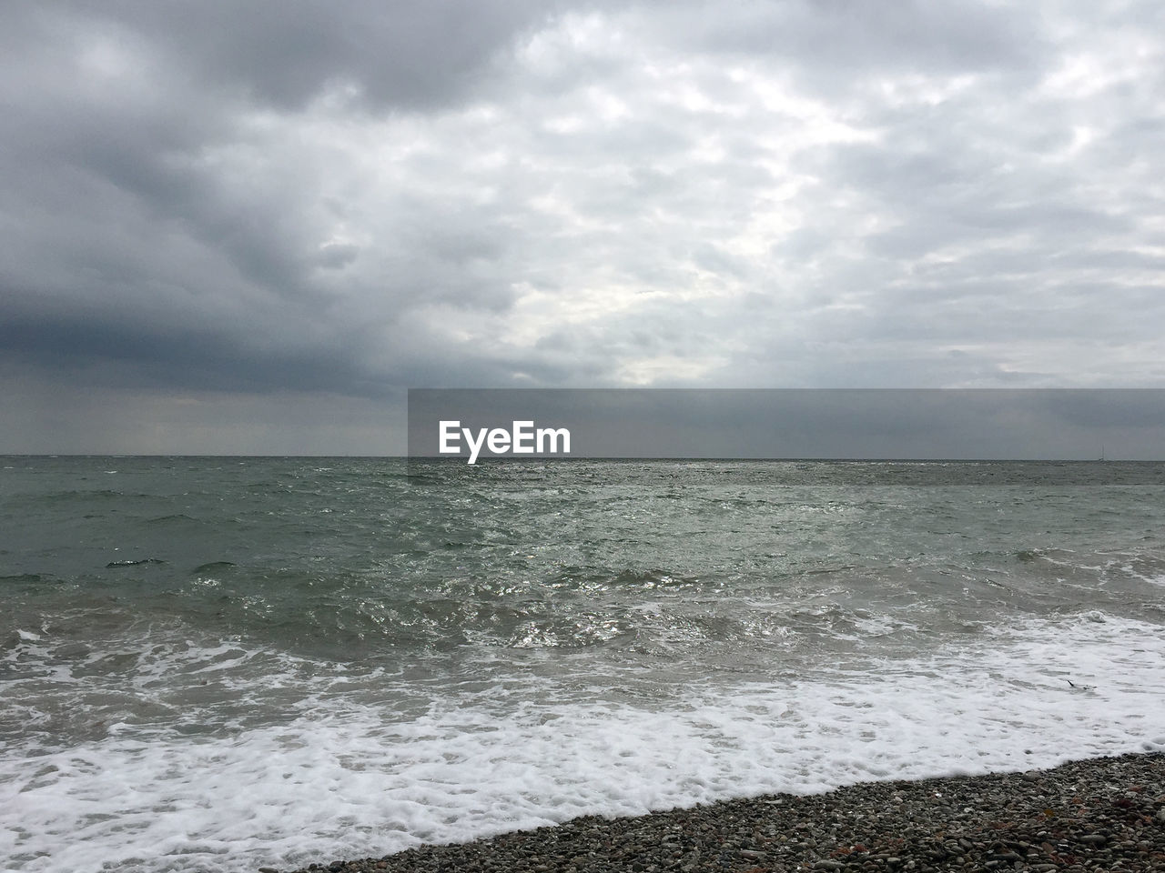 SCENIC VIEW OF SEA AGAINST STORM CLOUD SKY