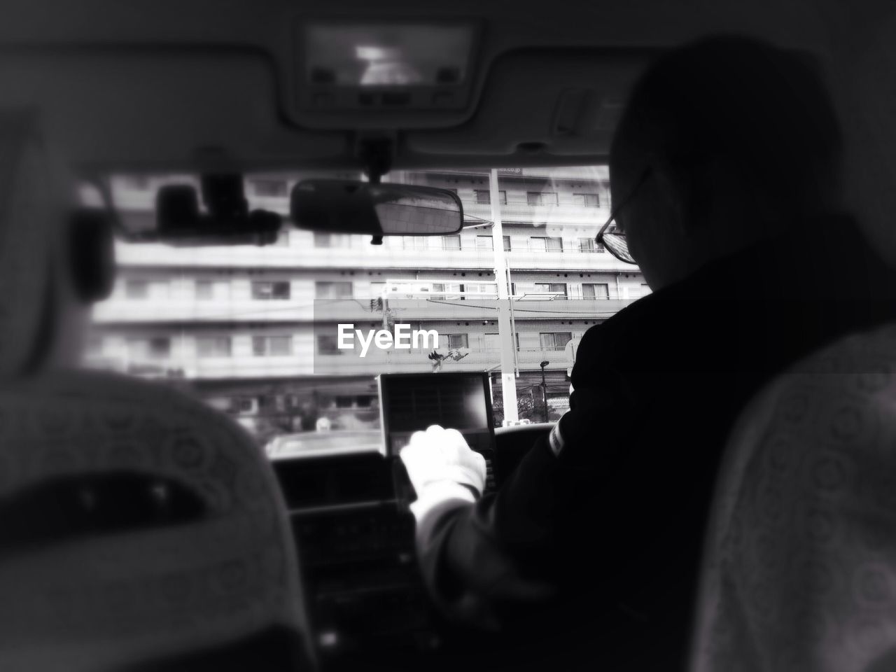 Rear view of man using gprs in the car