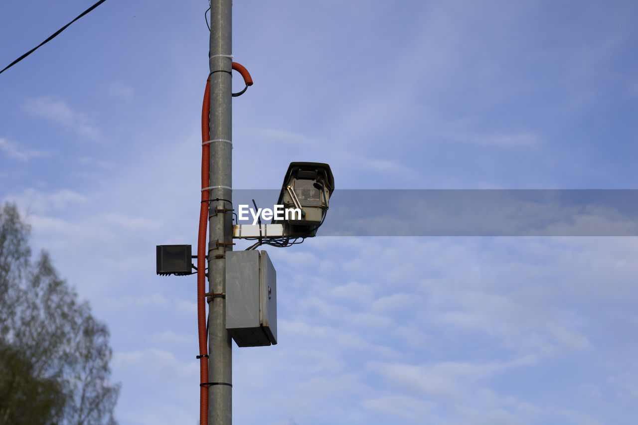 Low angle view of surveillance camera against sky
