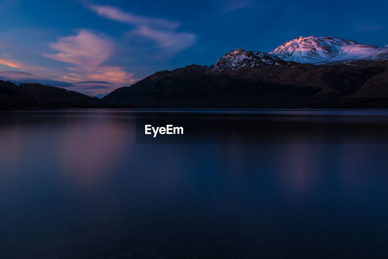 SCENIC VIEW OF LAKE AGAINST MOUNTAINS DURING WINTER