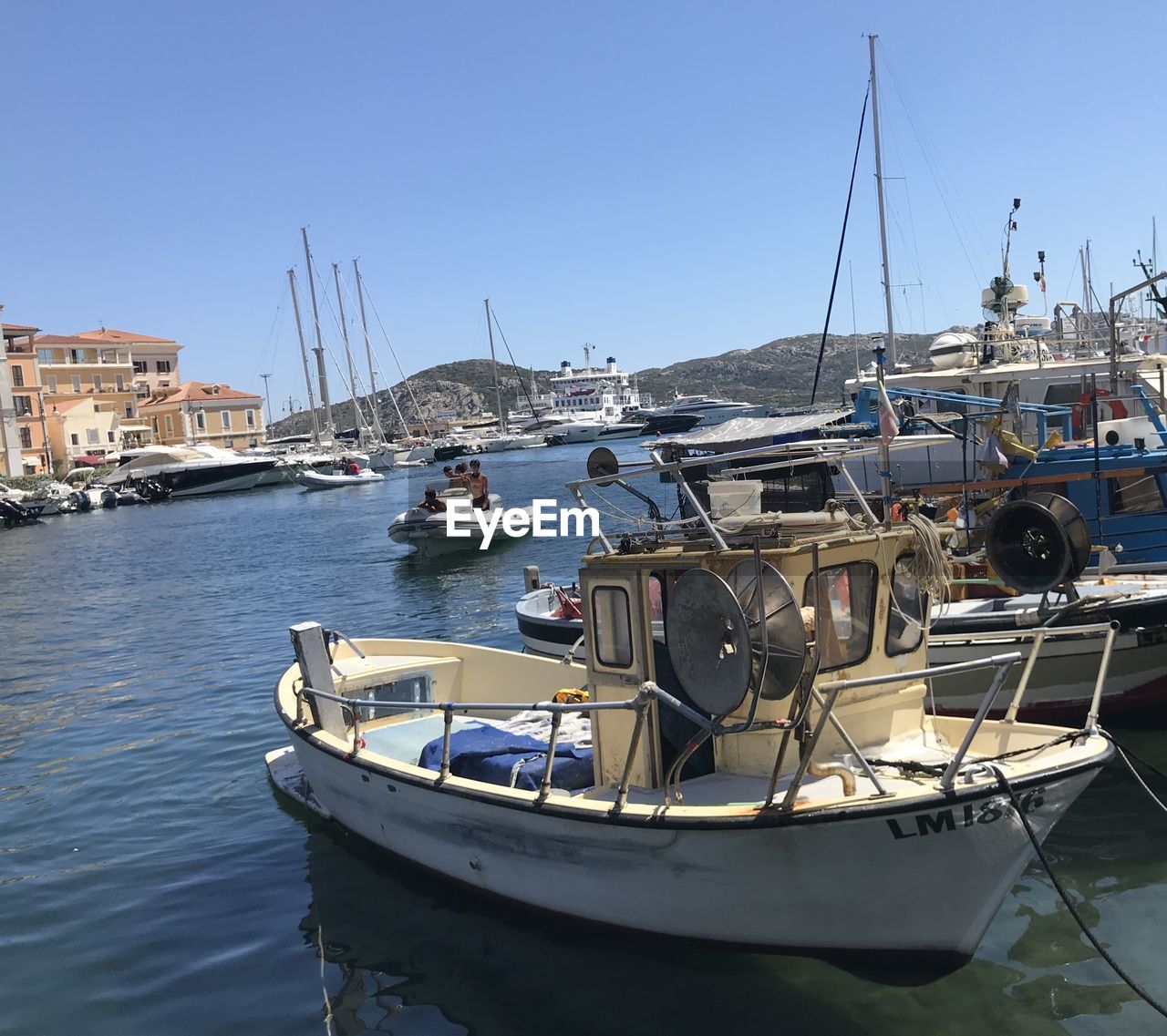 SAILBOATS MOORED AT HARBOR