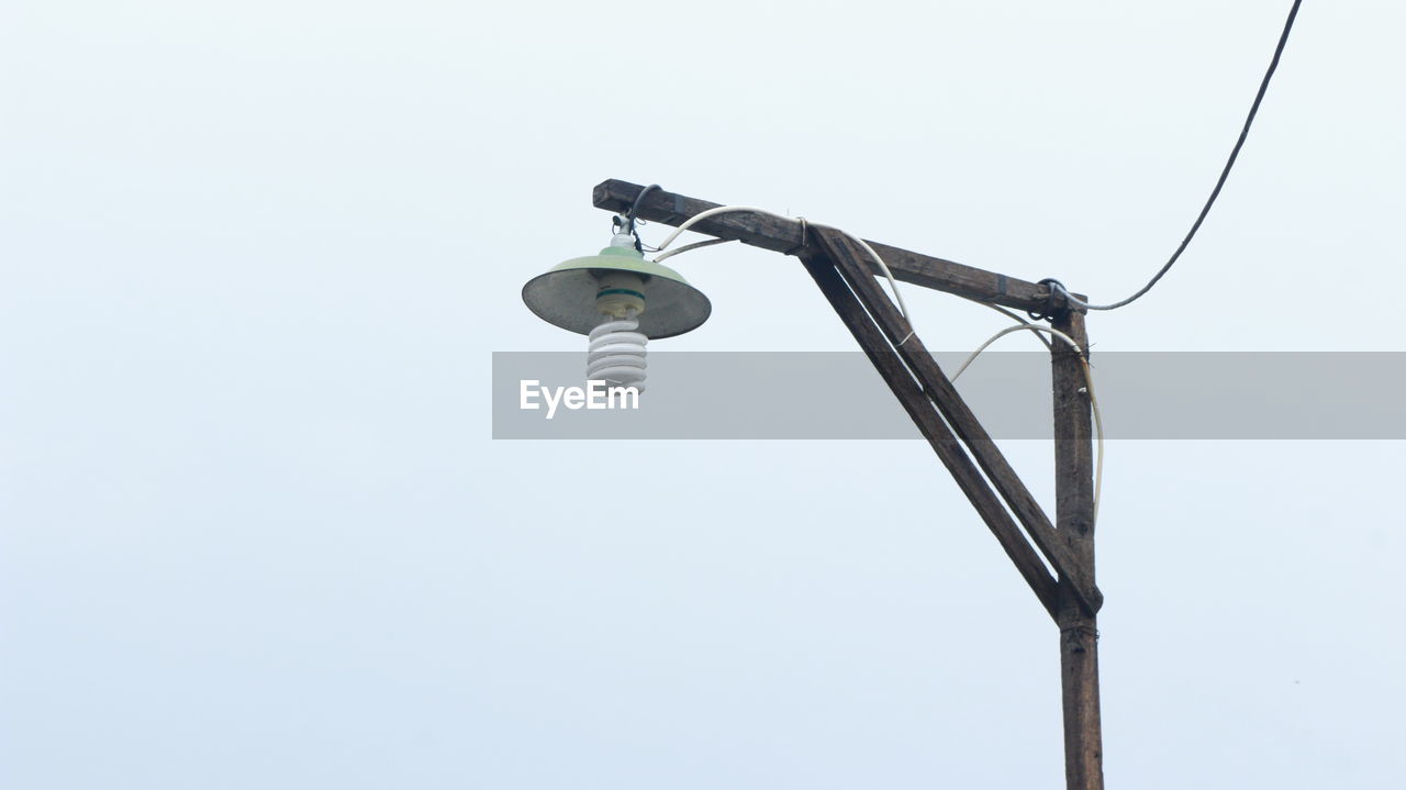 Low angle view of energy efficient lightbulb against clear sky