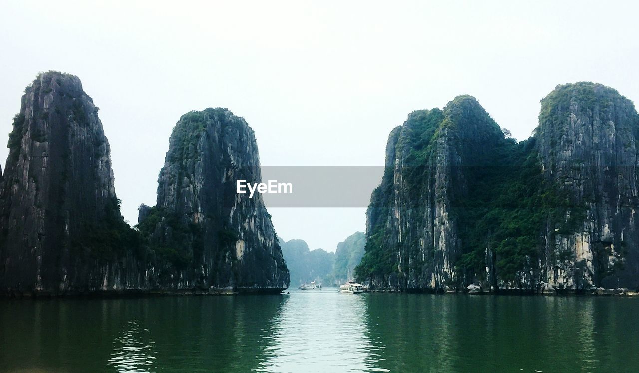 PANORAMIC VIEW OF SEA AND ROCK FORMATION AGAINST CLEAR SKY