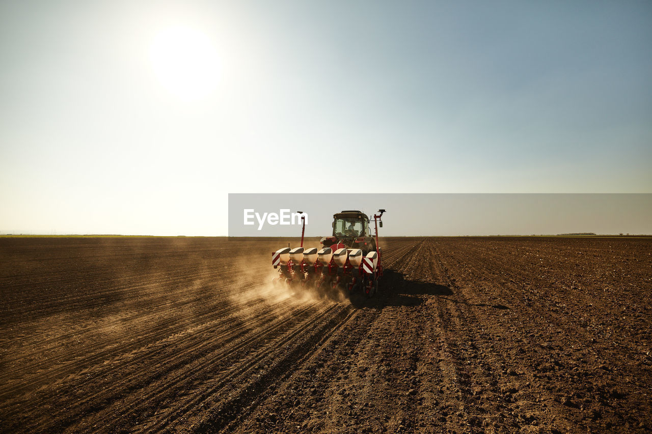 Tractor with seeder sowing crops at soybean farm