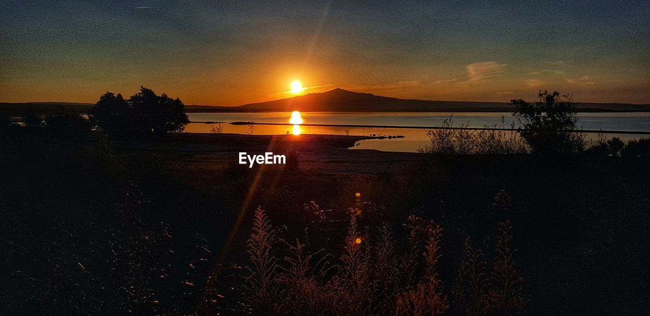 SCENIC VIEW OF LAKE AGAINST ORANGE SKY