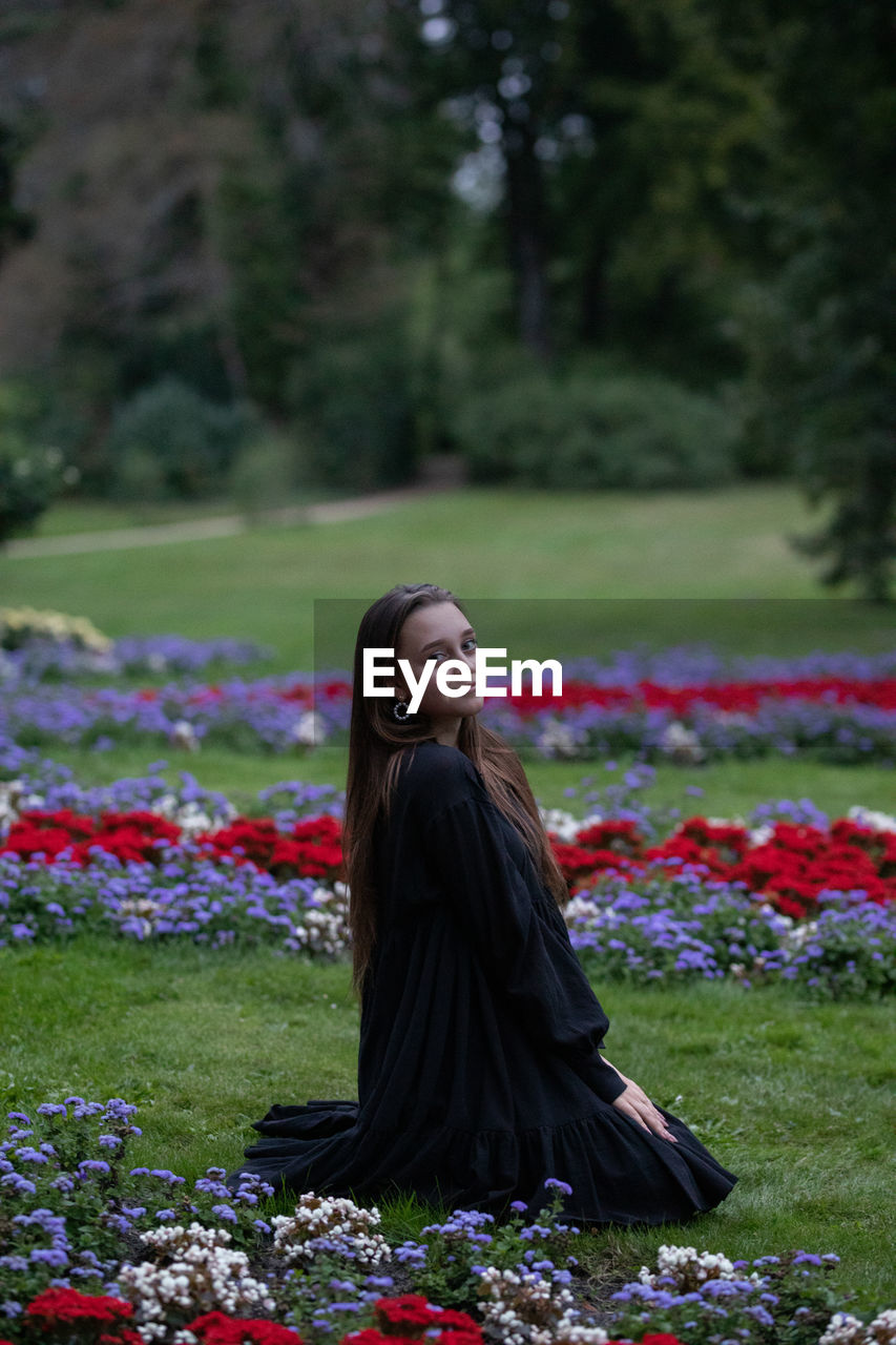 Woman looking at camera while standing on field