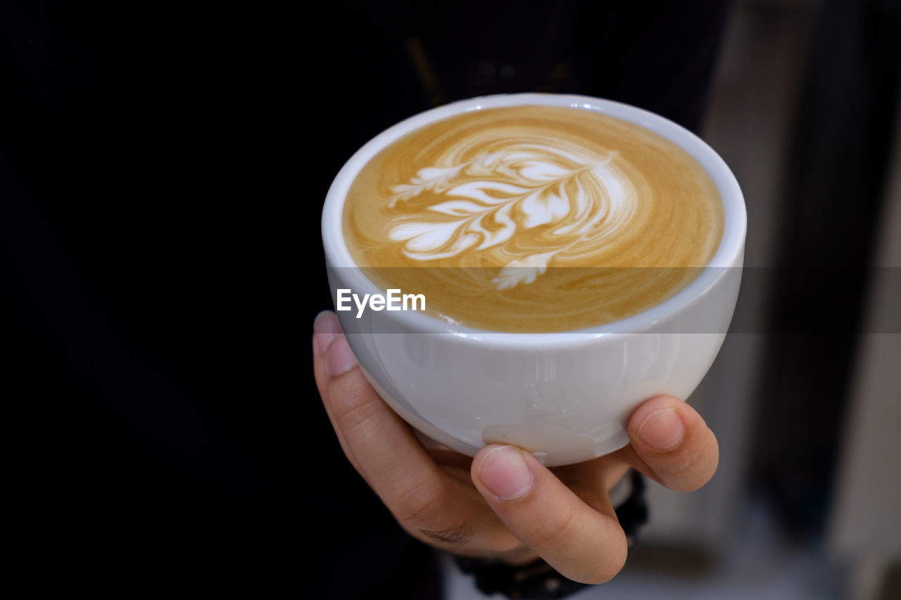 Close-up of hand holding coffee cup