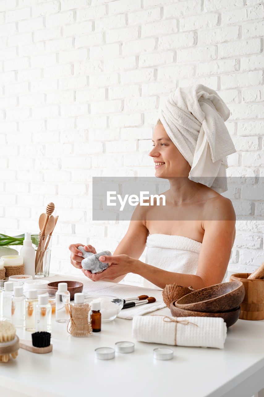 Young woman with beauty products on table