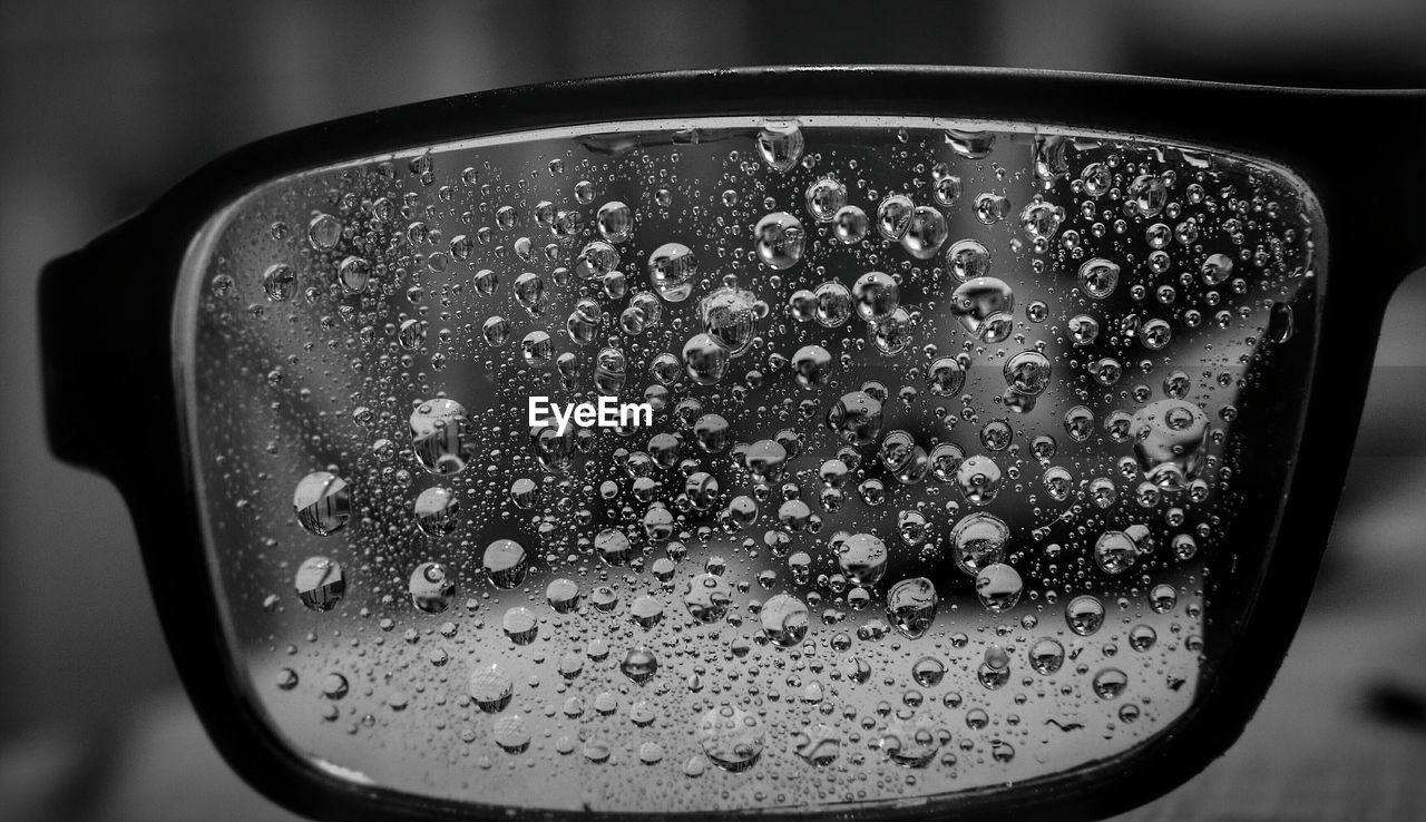 Cropped image of wet eyeglasses