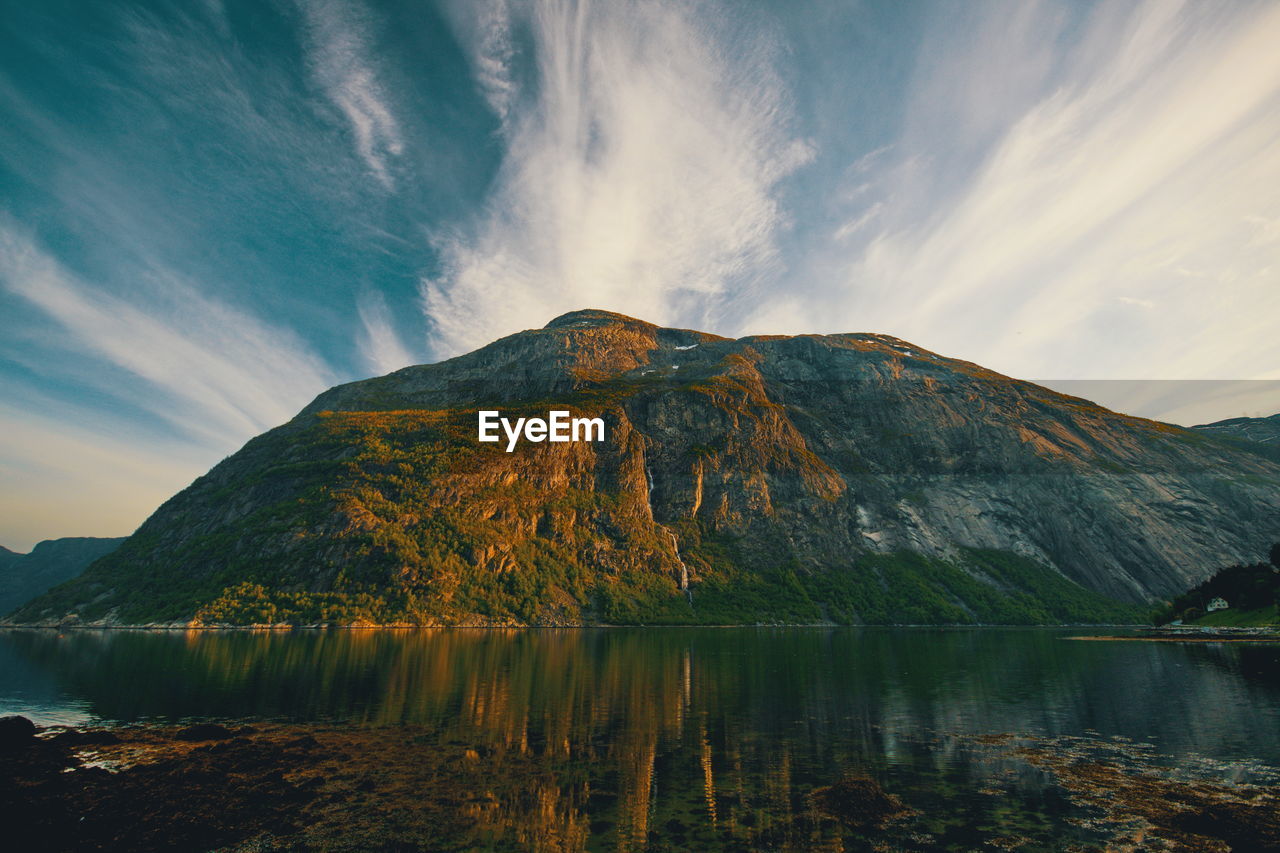 Scenic view of lake by mountain against sky