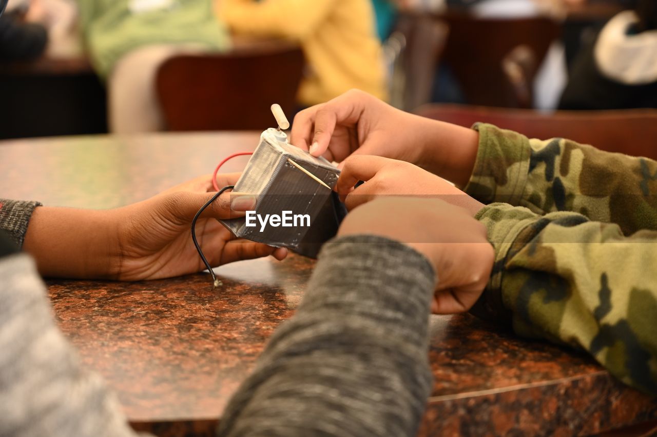 CLOSE-UP OF HANDS HOLDING CAMERA