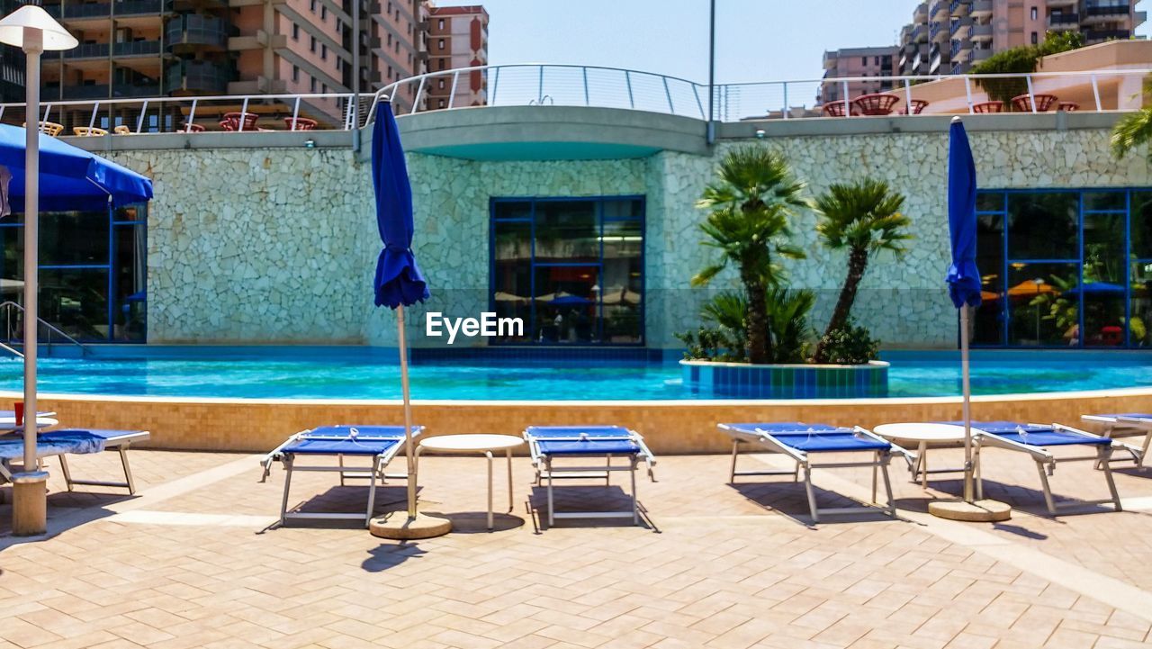 CHAIRS AND SWIMMING POOL AGAINST BUILDING