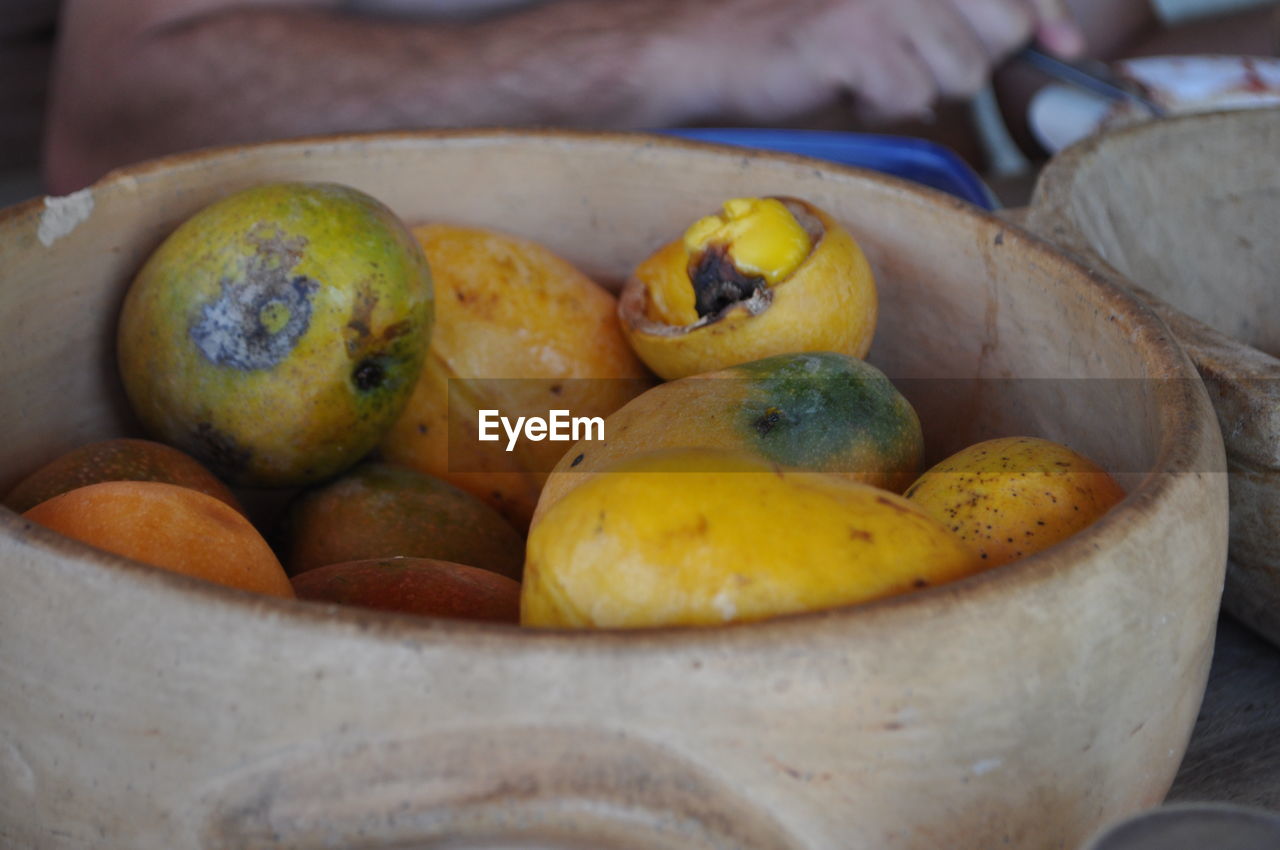 Close-up of mangoes in wooden bowl