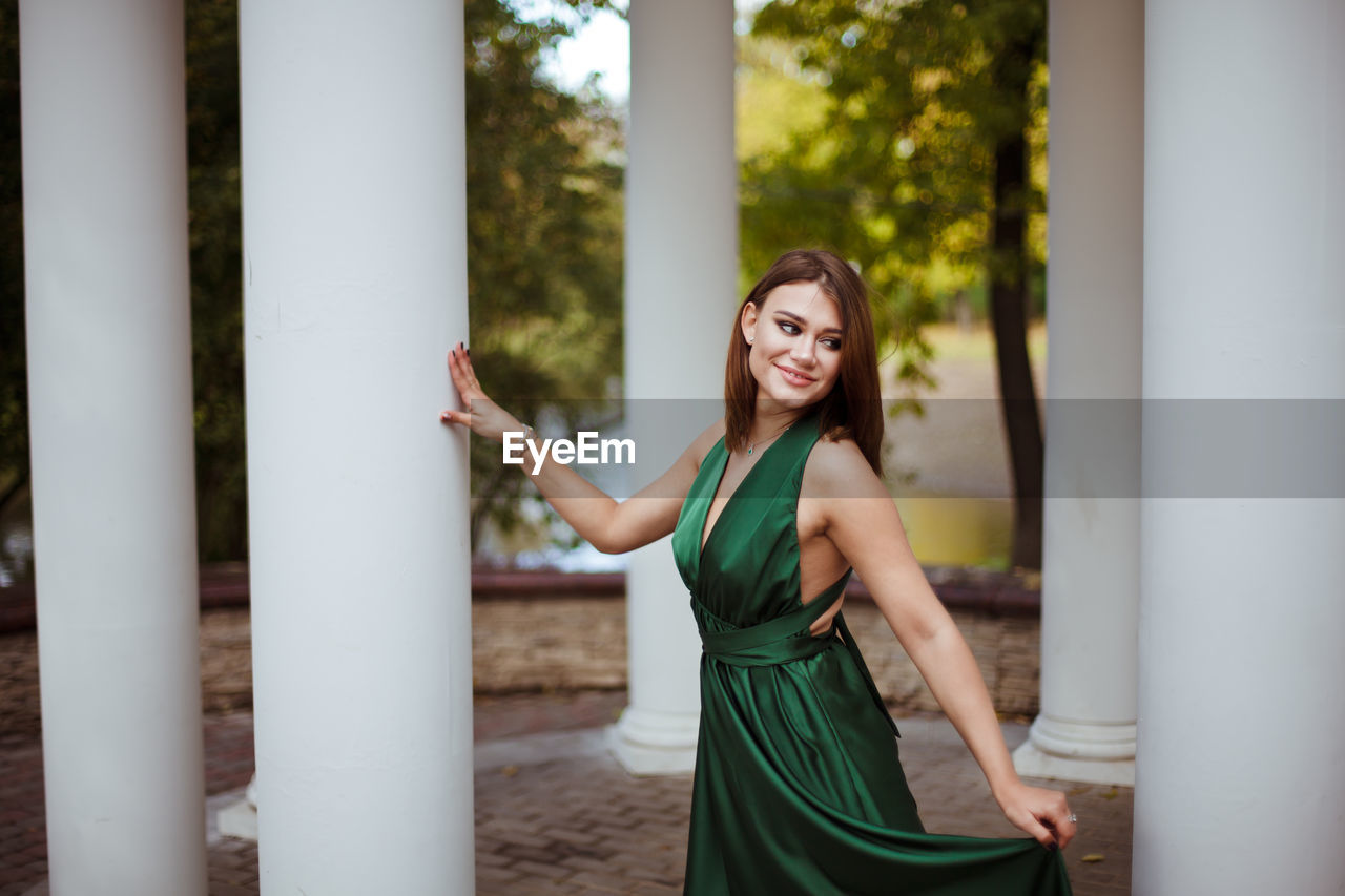 Smiling young woman looking away while standing outdoors