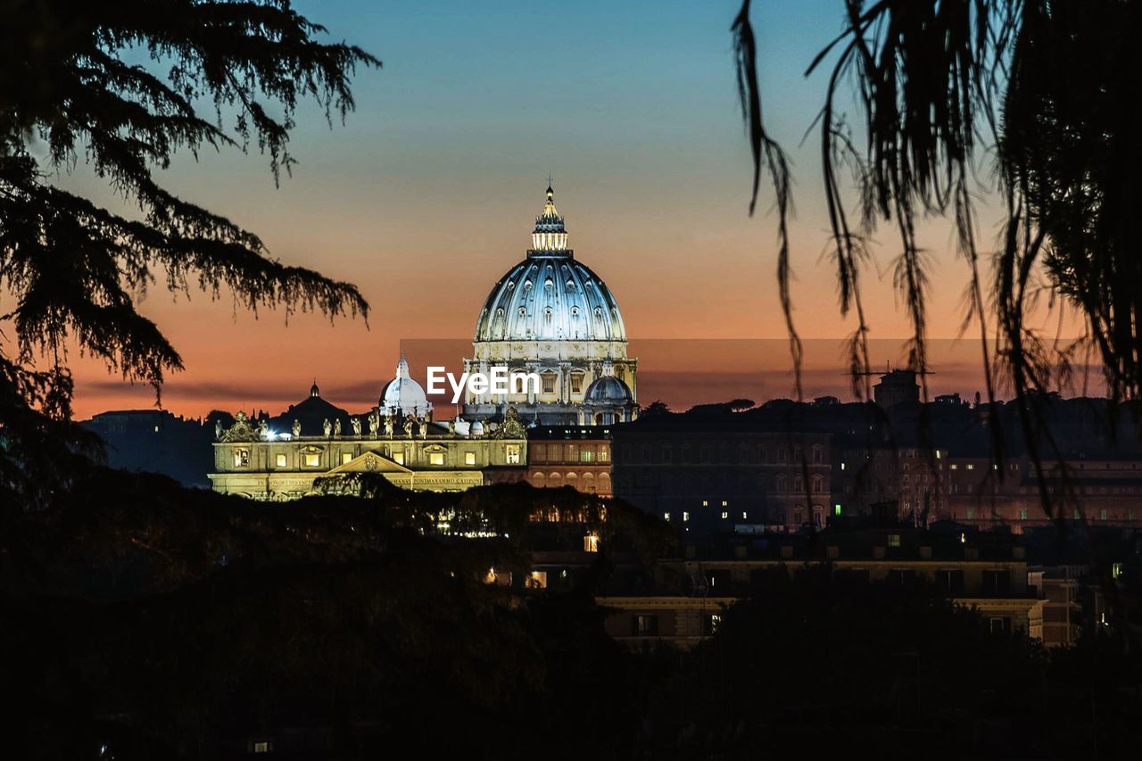 View of illuminated buildings in city during sunset