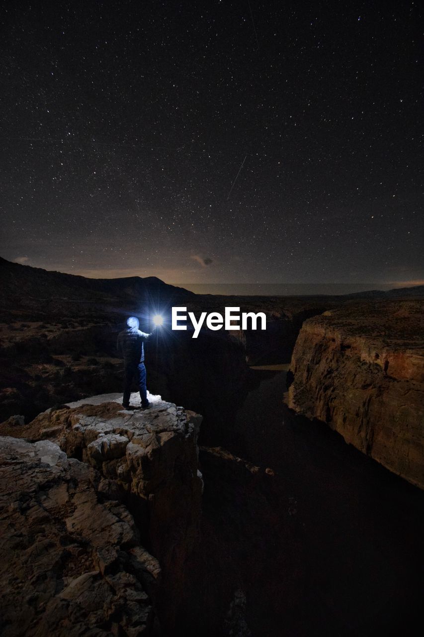 SCENIC VIEW OF ILLUMINATED ROCK AGAINST SKY