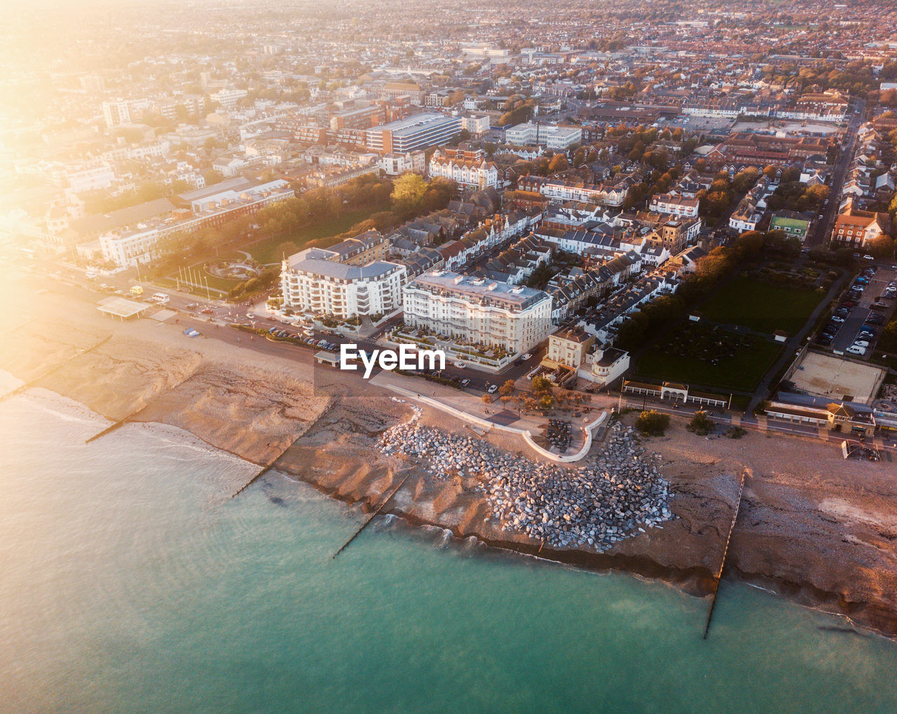 High angle drone view of buildings in city of worthing on the sea front at sunset