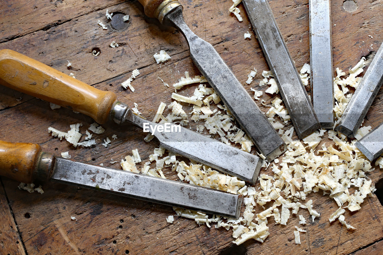 Close-up of chisel and wood shavings on table