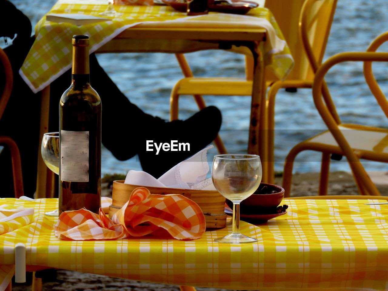 Low section of man sitting at table on riverbank