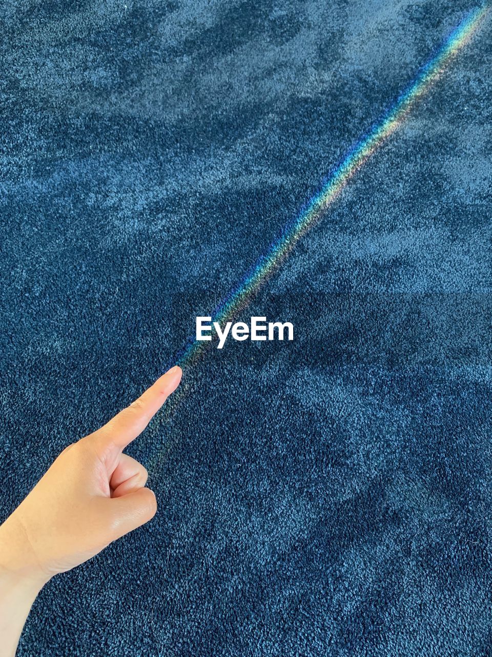 HIGH ANGLE VIEW OF PERSON HAND ON MULTI COLORED